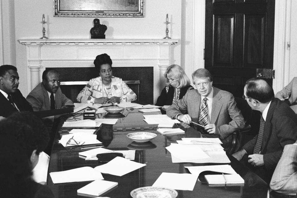 FILE - President Jimmy Carter meets with his commission for the appointment of blacks to the federal judiciary in the fifth circuit at the White House in Washington Wednesday, June 29, 1977. From left are: Horace Tate, Georgia state senator; Joe Reid; Coretta King, widow of Martin Luther King Jr.; Margaret McKenna, a staff aide; Carter; and Attorney General Griffin Bell. (AP Photo/Harvey Georges, File)