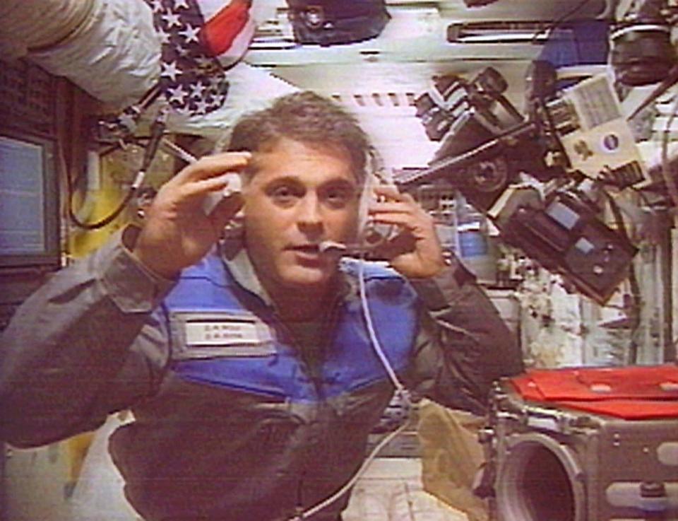 Astronaut David Wolf, the first American to vote in space, gestures as he answers a question during a televised Oct. 16, 1997 interview from the Mir space station.