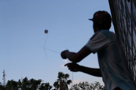 A youth flies a homemade kite next to Gran Mision Vivienda housing project in Caracas, Venezuela, March 20, 2019. The children make their own kites using a plastic bag, sticks and a nylon line. "Most expensive is the nylon cone, which is 10 thousand Bolivar notes (approximately 3 U.S. dollars)," said Luis Flores. REUTERS/Ivan Alvarado