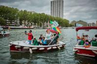 <p>A flotilla of small boats waving rainbow flags celebrate Pride in Paris.</p>