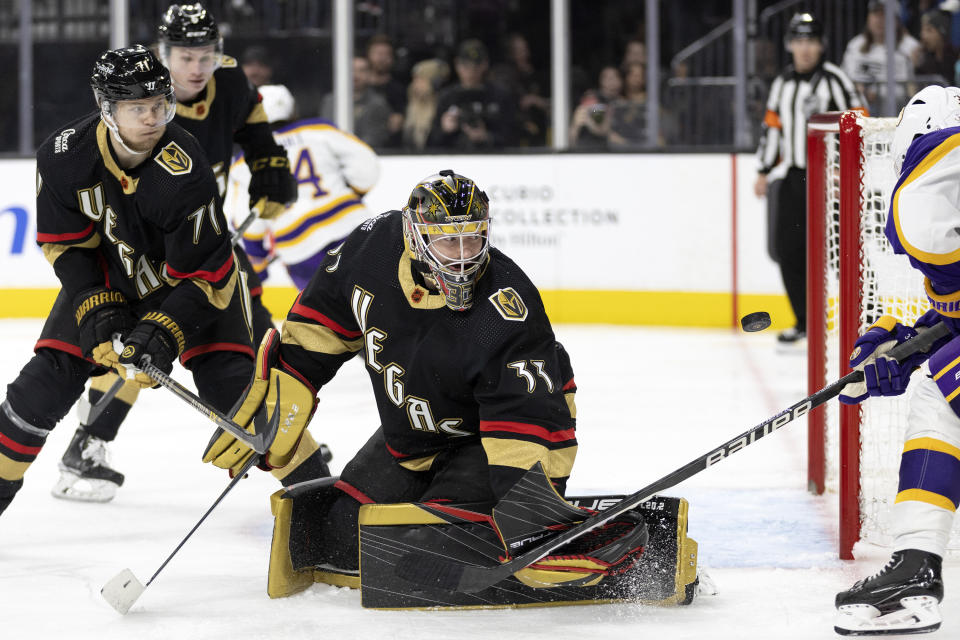 Los Angeles Kings right wing Viktor Arvidsson, partially seen at right, scores a goal on Vegas Golden Knights goaltender Adin Hill (33) while center William Karlsson (71) watches during the third period of an NHL hockey game Saturday, Jan. 7, 2023, in Las Vegas. (AP Photo/Ellen Schmidt)