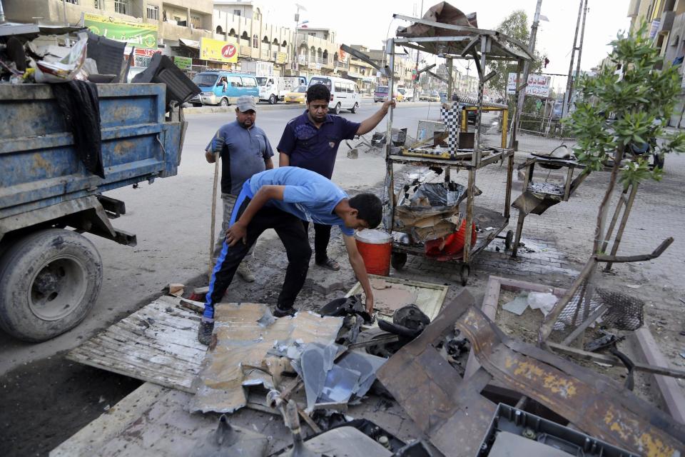 Baghdad municipality workers clean up in the aftermath of a car bomb attack in a crowded commercial street in Baghdad's eastern neighborhood of Sadr City, Iraq, Tuesday, April 22, 2014. Suicide bombings and other attacks across Iraq killed and wounded dozens on Monday, officials said, the latest in an uptick in violence as the country counts down to crucial parliamentary elections later this month. (AP Photo/Karim Kadim)