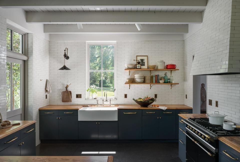 The kitchen features floor-to-ceiling tiles handmade in Portland. The sconce is by Hector Finch.