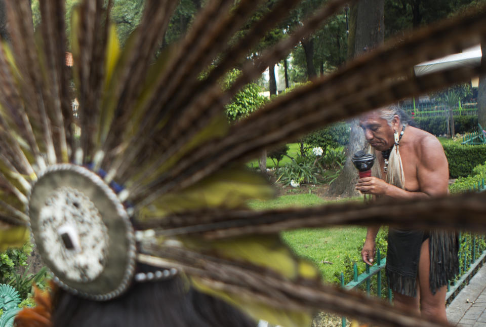 Street performers Tezka Mendozadira, right, and Judit Pozos wear Aztec garb as they earn money by performing blessings with incense and a conch shell, in the central square in Xochimilco, on the southern edge of Mexico City, Wednesday, May 7, 2014. In Xochimilco, busy markets stand side by side with colonial churches, and children ride to school in boats pushed by poles, along a network of canals and floating gardens that date to pre-hispanic times. The popular tourist destination was declared a UNESCO world heritage site in 1987. (AP Photo/Rebecca Blackwell)