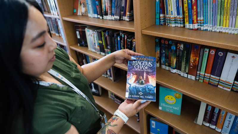 Rose Yazzie, library technology coach at Valley Junior High School, gives a tour of the library’s Spanish book section in West Valley City on Thursday, May 11, 2023.