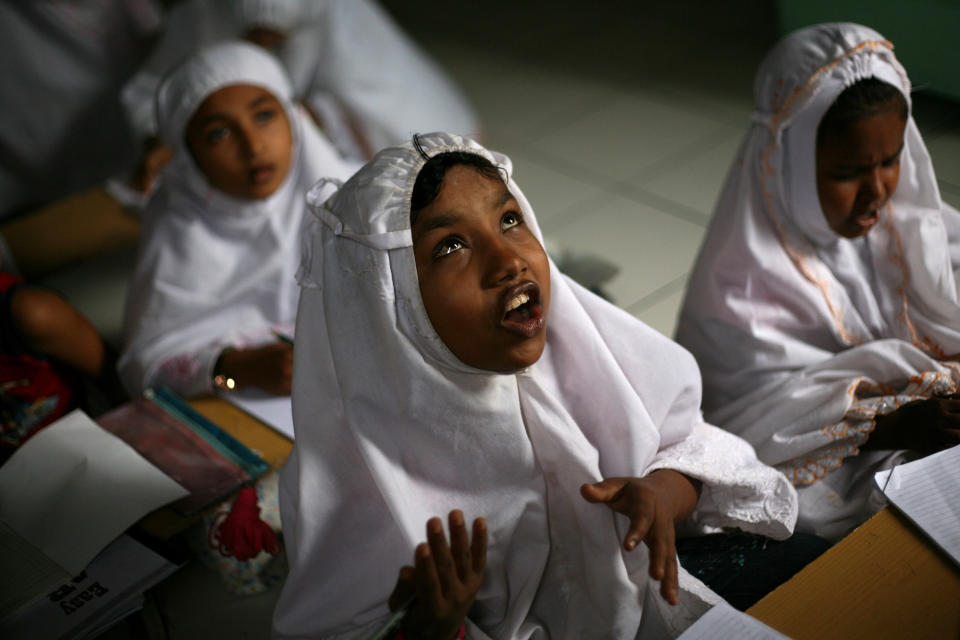 In this Oct. 11, 2013 photo, young ethnic Rohingya asylum seeker Senwara Begum from Myanmar, center, attends an English class at her temporary shelter in Medan, North Sumatra, Indonesia. Indonesia has been sympathetic to the Rohingya, and its president has sent a letter to his Myanmar counterpart calling for an end to the crisis. (AP Photo/Binsar Bakkara)