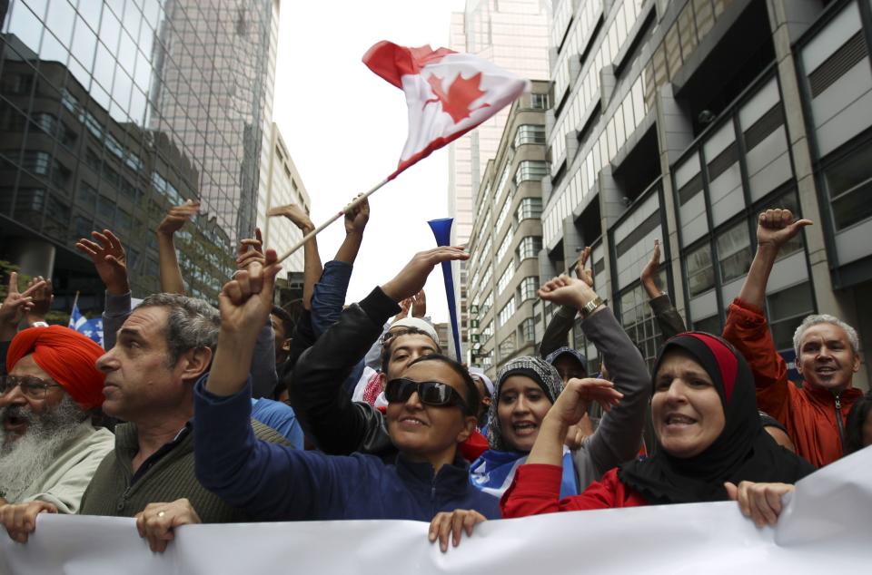 Demonstrators take to the streets to protest against Quebec's proposed Charter of Values in Montreal, September 14, 2013. Thousands took to the streets to denounce the province's proposed bill to ban the wearing of any overt religious garb by government paid employees. REUTERS/Christinne Muschi (CANADA - Tags: POLITICS CIVIL UNREST RELIGION)