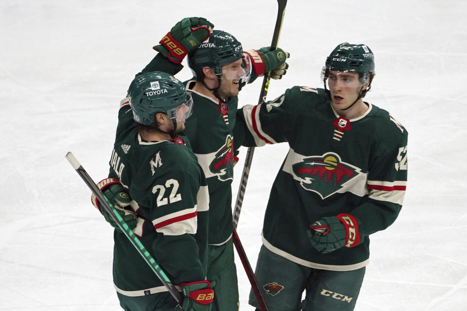 Minnesota Wild's Kevin Fiala (22) and Connor Dewar (52) congratulate Minnesota Wild's Dmitry Kulikov on his goal off San Jose Sharks goalie James Reimern in the first period of an NHL hockey game, Sunday, April 17, 2022, in St. Paul, Minn. (AP Photo/Jim Mone)