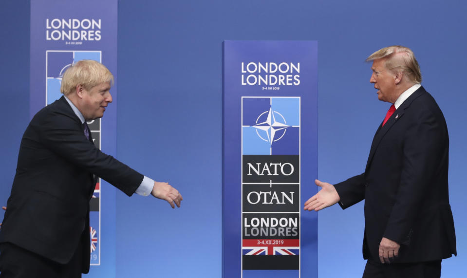 British Prime Minister Boris Johnson, left, reaches out to shake hands with U.S. President Donald Trump at the official arrivals for a NATO leaders meeting at The Grove hotel and resort in Watford, Hertfordshire, England, Wednesday, Dec. 4, 2019. NATO Secretary-General Jens Stoltenberg rejected Wednesday French criticism that the military alliance is suffering from brain death, and insisted that the organization is adapting to modern challenges. (AP Photo/Francisco Seco)