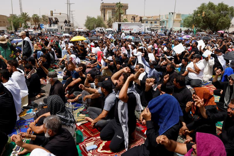 Los partidarios del líder populista iraquí Moqtada al-Sadr se reúnen para la oración masiva del viernes frente al parlamento cerca de la Zona Verde, en Bagdad, Irak