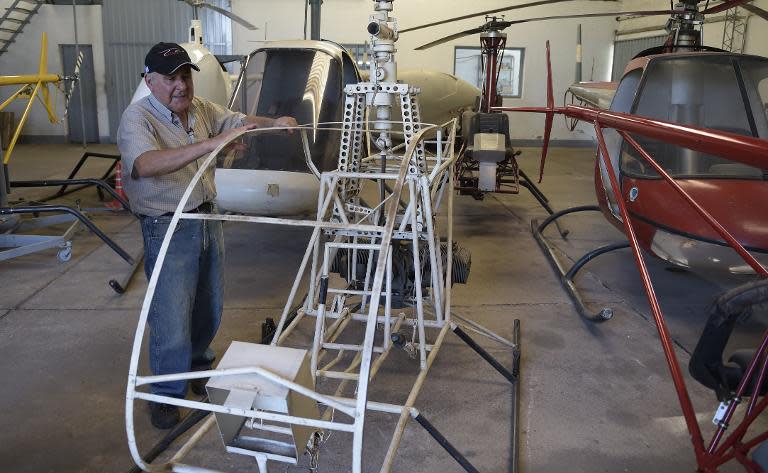 Argentine helicopter designer and builder Augusto Cicare touches the CH-1, his first hand-made helicopter that eventually took off in 1961, during an interview with AFP at his factory in Saladillo, west of Buenos Aires on February 23, 2015