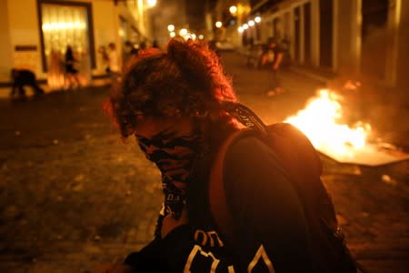 A demonstrator reacts during clashes with the police in a protest calling for the resignation of Governor Ricardo Rossello in San Juan