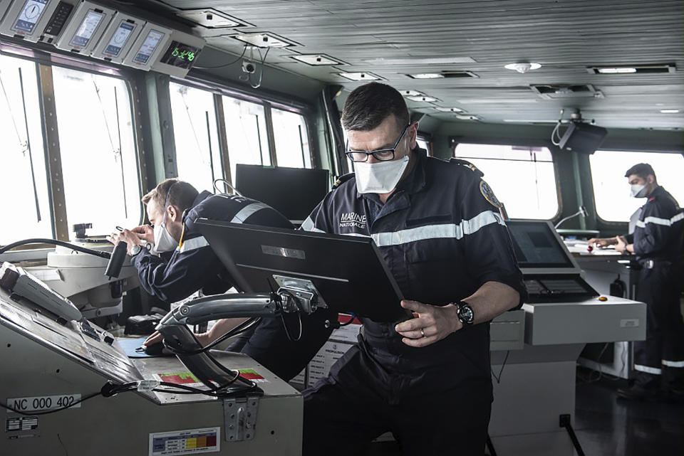 This photo provided Saturday April 10, 2020 by the French Navy (Marine Nationale) shows sailors wearing face masks aboard the French aircraft carrier Charles de Gaulle, Thursday April 8, 2020 in the Atlantic Ocean. France's only aircraft carrier has confirmed 50 cases of the new virus aboard and is heading back to port. Three of those aboard the Charles de Gaulle with the virus have been flown to French hospitals for treatment, the French military said in a statement Friday .The new coronavirus causes mild or moderate symptoms for most people, but for some, especially older adults and people with existing health problems, it can cause more severe illness or death. (Y. Bisson/Marine Nationale via AP)