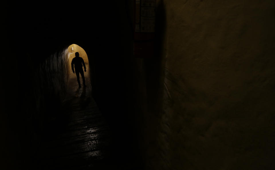 En esta imagen del 28 de octubre de 2017, el camarero ciego Óscar Pitiur camina en “La Cueva de Rafa”, un restaurante situado a 12 metros bajo tierra en Quito, Ecuador. (AP Foto/Dolores Ochoa)