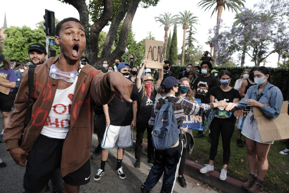 A "Black Lives Matter" protesters screams at a line of police during a protest outside Los Angeles Mayor Eric Garcetti's house.