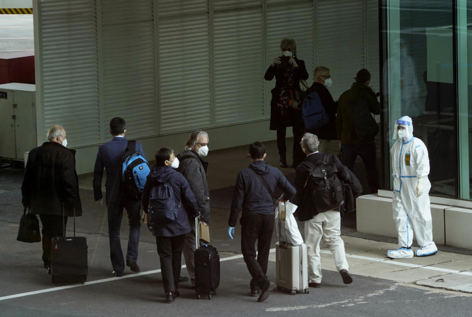 Members of the World Health Organization (WHO) team arrive at the airport in Wuhan in central China's Hubei province on Thursday, Jan. 14, 2021. A global team of researchers arrived Thursday in the Chinese city where the coronavirus pandemic was first detected to conduct a politically sensitive investigation into its origins amid uncertainty about whether Beijing might try to prevent embarrassing discoveries. (AP Photo/Ng Han Guan)