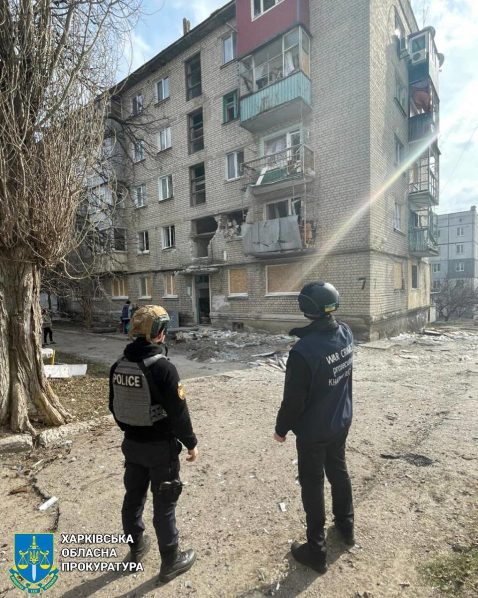 Law enforcement officers observe the damage Russian shelling caused to an apartment building in Kupiansk, Kharkiv Oblast, on March 26. (Kharkiv Oblast Prosecutor's Office) 