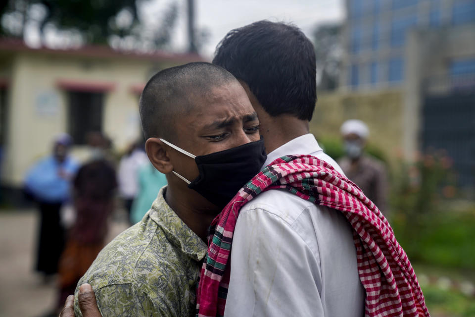 In this May 20, 2020, photo, provided by UNICEF, Mohammed Rakib, 15, who was accused of beating a man and sent to an overcrowded detention center, cries while hugging his father after being released in Tongi, on the outskirts of Dhaka, Bangladesh. Authorities in Bangladesh have been releasing hundreds of children suspected of committing mostly petty crimes as they try to keep the coronavirus from spreading in overcrowded detention centers, officials said Friday. The orders for their release on bail came from virtual courts set up by the country's Supreme Court with the help of UNICEF, officials said. "It feels great to be freed and get united with my parents," Rakib told The Associated Press on Friday. "I am very happy. I have suffered in the jail a lot. That's a bad place." (UNICEF via AP)