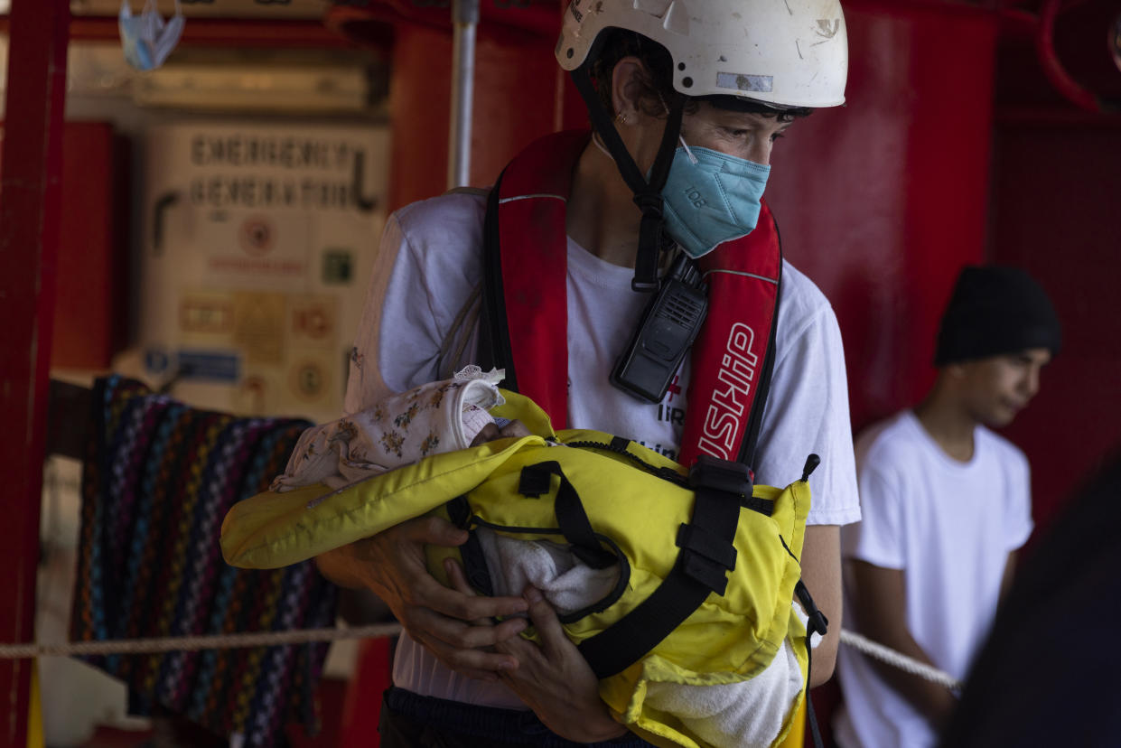 A volunteer midwife evacuates a three-week old baby from the Ocean Viking, a migrant search and rescue ship run by NGOs SOS Mediterranee and the International Federation of Red Cross (IFCR), Monday, Aug. 29, 2022 in the Mediterranean Sea. Two 9-month-pregnant women whose pregnancy were at risk, travelling with their sisters and two children, including the 3-week-old girl were transferred to an Italian coastguard vessel fort rated. 466 migrants are on board the Ocean Viking. (AP Photo/Jeremias Gonzalez).