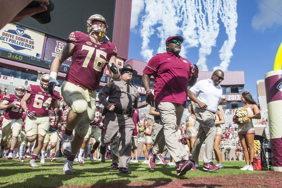 Florida State interim head coach Odell Haggins (C) and OL Rick Leonard take the field against Louisiana Monroe in Tallahassee, Fla., Saturday, Dec. 2, 2017. (AP Photo/Mark Wallheiser)