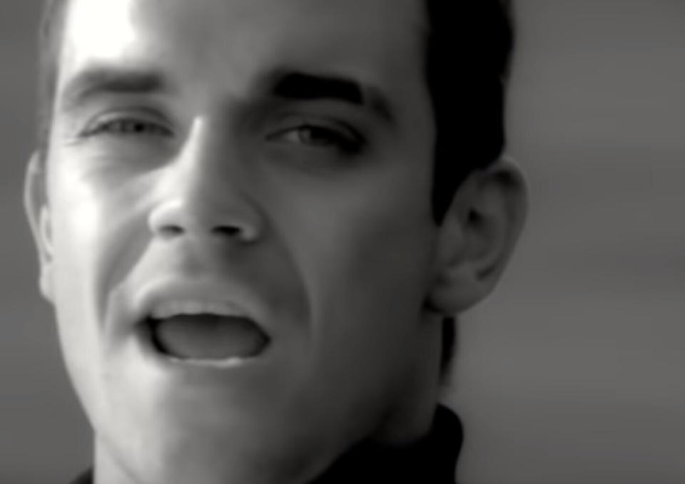 Robbie Williams sings in the music video for his 1997 single 'Angels'. (Credit: YouTube/Chrysalis Records)