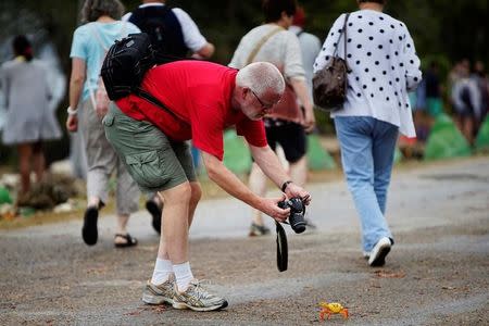 A tourist takes a photograph of a crab coming from the surrounding forests to spawn in the sea in Playa Giron, Cuba, April 21, 2017. Picture taken on April 21, 2017. REUTERS/Alexandre Meneghini