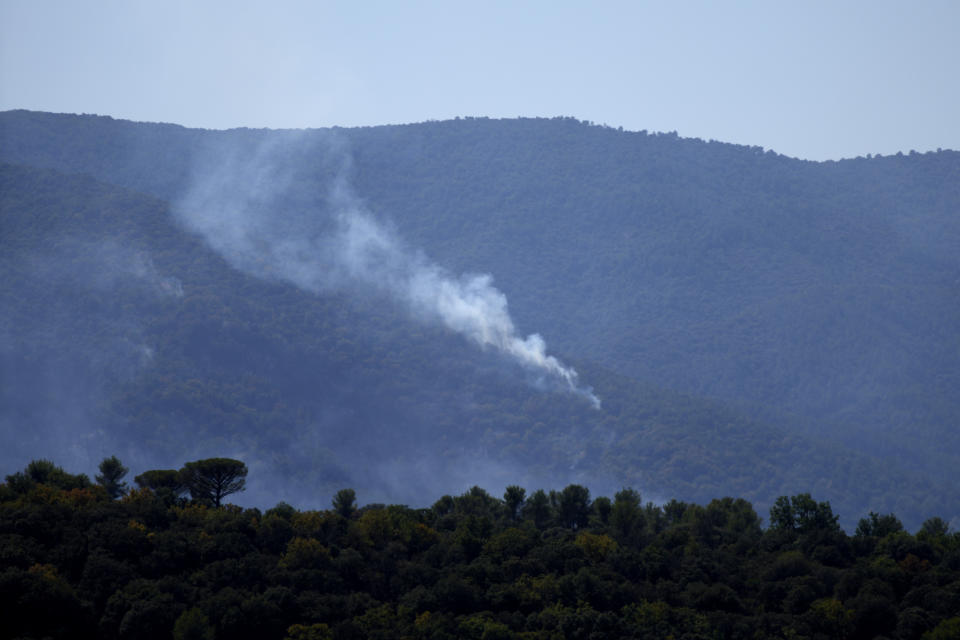 Smoke billows from the forest near La Garde-Freinet, southern France, Tuesday, Aug. 17, 2021. Hundreds of firefighters on Tuesday battled a fire racing through forests near the French Riviera that forced the evacuation of thousands of people from homes and vacation spots. (AP Photo/Daniel Cole)