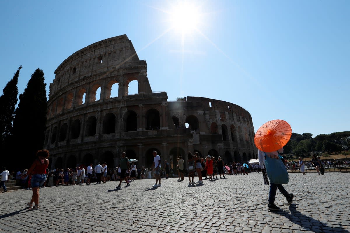 People walk near the Colosseum during a new heatwave as temperatures are expected to reach 40 degrees Celsius in some cities (REUTERS)