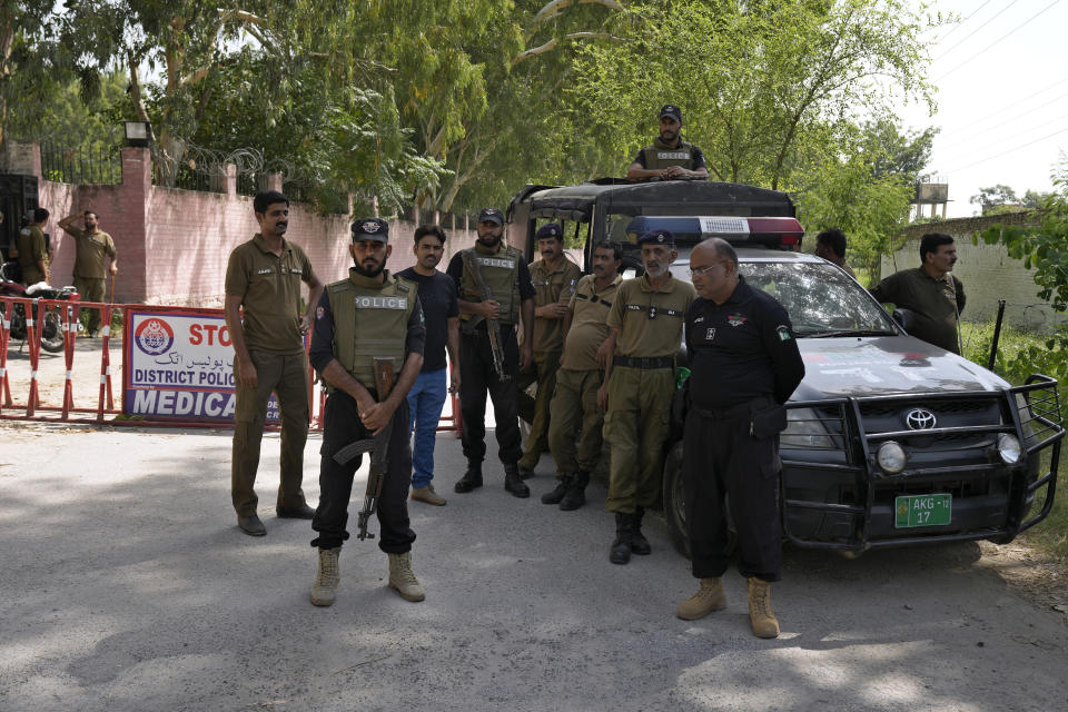 Police officers stand guard at a checkpoint on a road leading to the District Jail, in Attock, Pakistan, Wednesday, Aug. 30, 2023. A court asked the official in charge of the Attock prison to keep former Prime Minister Khan there until at least Wednesday, when Khan is expected to face a hearing on charges of "exposing an official secret document" in an incident last year when he waved a confidential diplomatic letter at a rally. The Islamabad High Court on Tuesday suspended the corruption conviction and three-year prison term of him, his lawyers and court officials said. (AP Photo/Anjum Naveed)