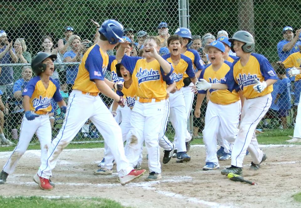 The Williston 11-12 All-Stars mob Theo Skapof after his home run in extra innings in the District 1 championship game on Tuesday night at Burlington's Schifilliti Field. Williston won the game 13-9 over Addison County.
