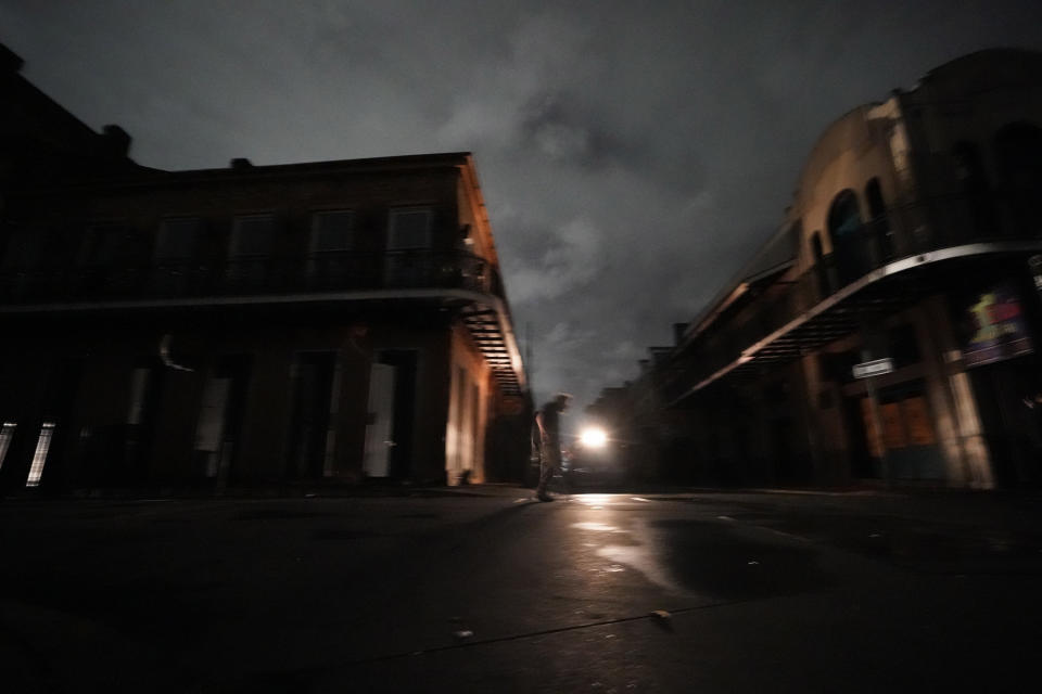 A man walks down Bourbon Street after the city lost power in the aftermath Hurricane Ida