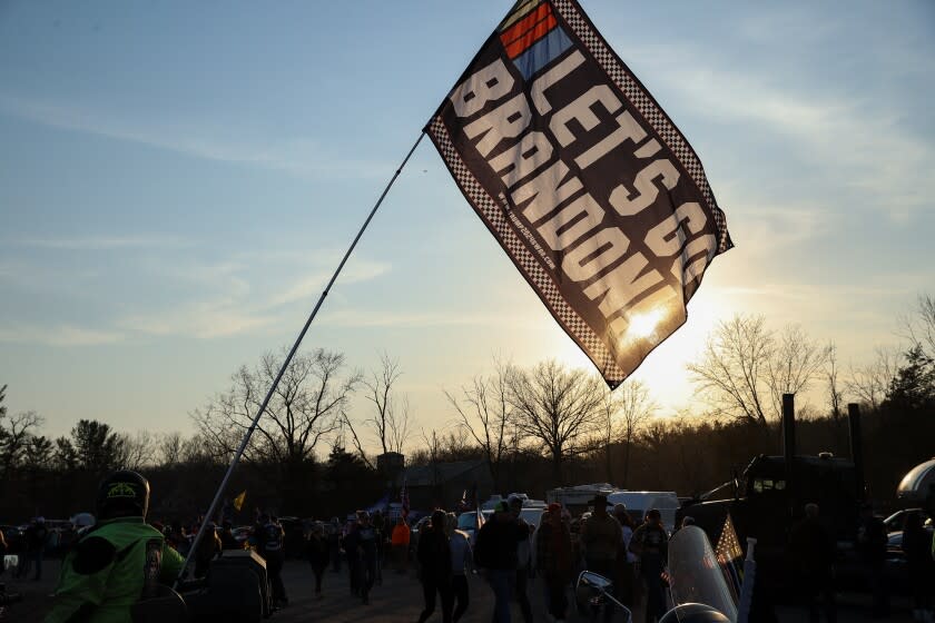 HAGERSTOWN, MARYLAND, USA - MARCH 5: A motorcyclist holds a flag that says "Let's go Brandon" as Truck convoy named also 'The People's Convoy' stay overnight in Hagerstown of Maryland, United States on March 5, 2022 as they are planned head to nation's capital on Sunday. The truckers leading the convoy are demanding an end to the vaccination mandates and full reopening of the country. (Photo by Tayfun Coskun/Anadolu Agency via Getty Images)