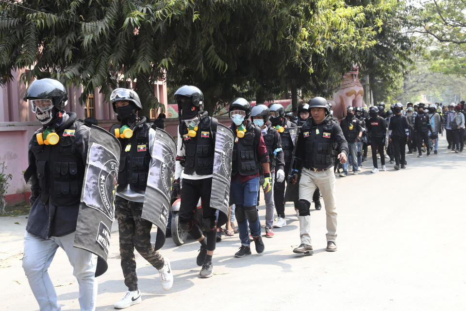 Anti-coup protesters wearing helmet and face mask march during a protest in Mandalay, Myanmar, Saturday, March 6, 2021. Demonstrators defied growing violence by Myanmar security forces and staged more anti-coup rallies Friday, while the U.N. special envoy for the country called for urgent Security Council action, saying about 50 peaceful protesters were killed and scores were injured in the military's worst crackdowns this week.(AP Photo)