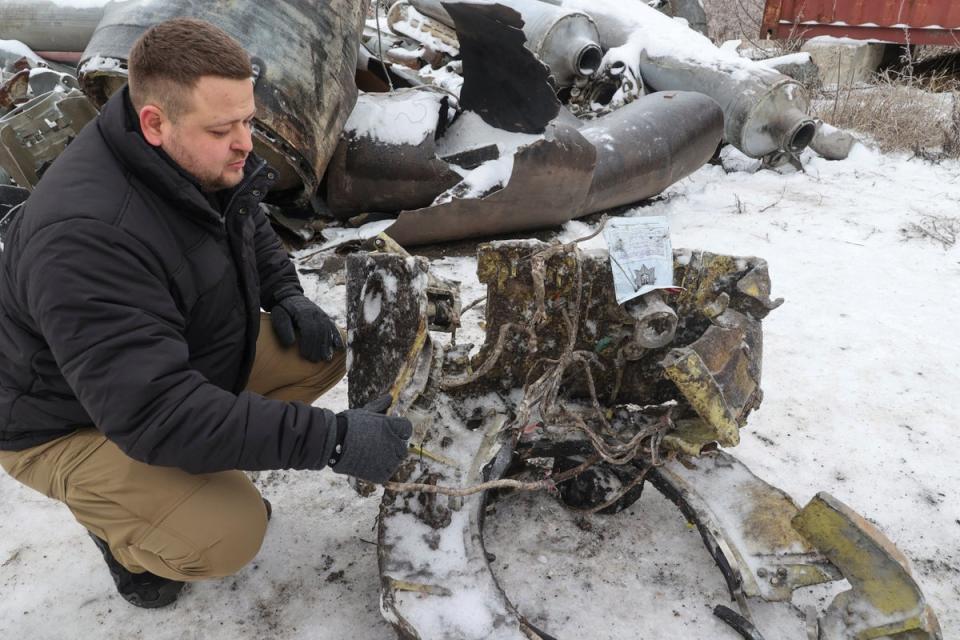 A representative from the prosecutor's office shows parts of an unidentified missile, which Ukrainian authorities believe to be made in North Korea and was used in a strike in Kharkiv (REUTERS)