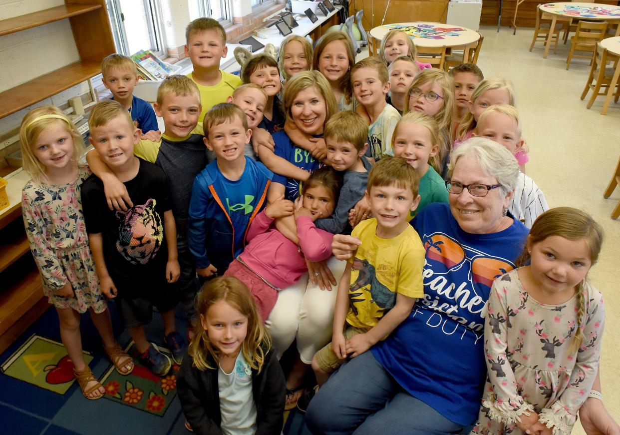 Ida Elementary kindergarten teacher Sherry Locke (center) and teaching assistant Carolyn Clark (right) sit for a photo among their students on their last day of school. The two educators are retiring.