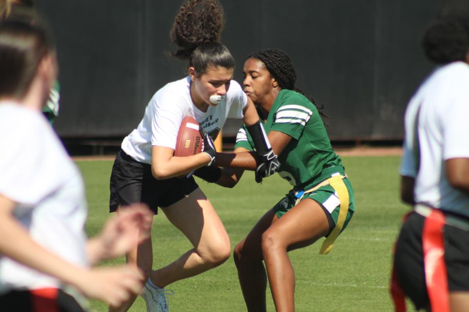 A Fleming Island player tries to pull the flag of her opponent during the 2022 preseason girls flag football tournament hosted by the Jaguars.
