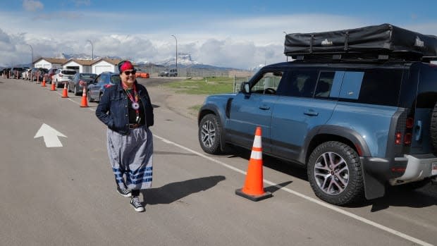 Bonnie Healey, health director for the Blackfoot Confederacy, chats with southern Alberta residents lining up at the border crossing at Carway, Alta., to get shots of a COVID-19 vaccine from the Blackfeet Tribe at a mobile clinic just over the border in Montana on May 18, 2021.  (Jeff McIntosh/Canadian Press - image credit)