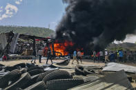 People run next to black smoke and flames in the aftermath at the scene of an airstrike in Mekele, the capital of the Tigray region of northern Ethiopia Wednesday, Oct. 20, 2021. New airstrikes have hit Mekele, residents said Wednesday, as Ethiopia's government said it was targeting facilities to make and repair weapons, which a spokesman for the rival Tigray forces denied. (AP Photo)