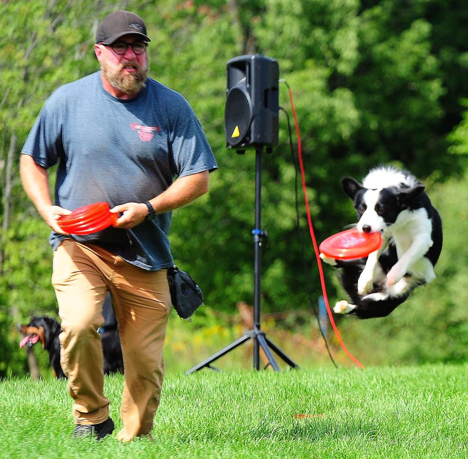 Bob Ryan of Performance Dogs of Ohio tosses a Frisbee to the pup Biscuit during the Bark in the Park event Sunday, Sept. 10, 2023, at Alliance's Coastal Pet-Burnell Dog Park.