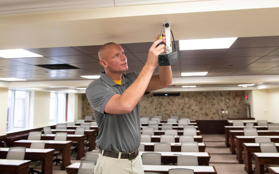 Adrian College plant service director Chris Stiver checks out one of the new remote learning video systems.