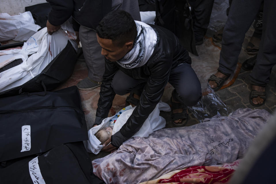 Palestinians mourn a baby killed in the Israeli bombardment of the Gaza Strip at a hospital morgue in Rafah, Monday, Feb. 12, 2024. The Israeli military said early Monday that it had rescued two hostages from captivity in the Gaza Strip. The operation, which was accompanied by airstrikes, killed dozens of Palestinians, according to local health officials. (AP Photo/Fatima Shbair)