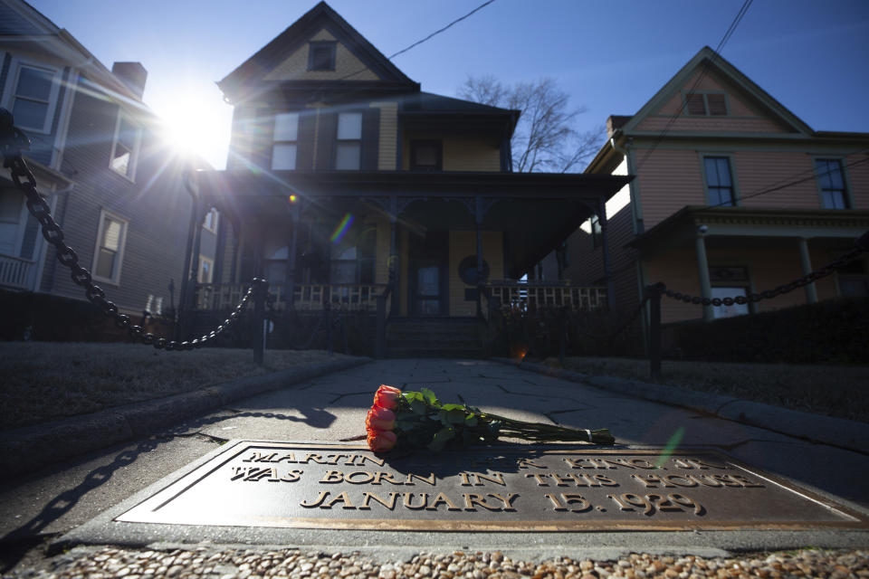 Flowers lay in front of the birthplace of Dr. Martin Luther King, Jr., on Monday, Jan. 18, 2021, in Atlanta. (AP Photo/Branden Camp)