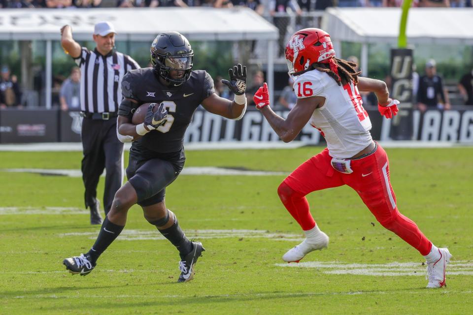 UCF Knights running back Mark-Antony Richards (6) carries the ball against Houston Cougars defensive back Brian George (16) during the second half at FBC Mortgage Stadium.