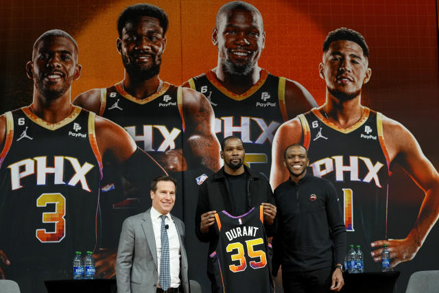 Phoenix Suns forward Kevin Durant, center, holds his jersey after being introduced during an NBA basketball team availability by owner Mat Ishbia, left, and general manager James Jones, Thursday, Feb. 16, 2023, in Phoenix. (AP Photo/Matt York)
