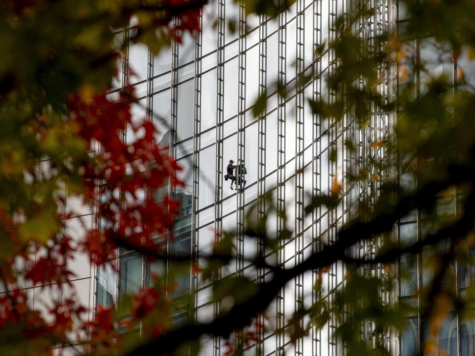 French urban climber Alain Robert, well known as "Spiderman", climbs down the 'Skyper' highrise in Frankfurt, Germany, Saturday, Sept. 28, 2019. (AP Photo/Michael Probst)