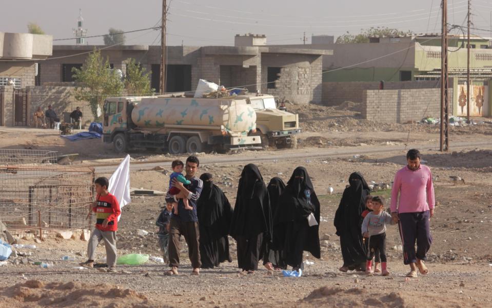 A group of IDPs coming to an aid and transport station, the child waves a white flag to signal they are not ISIS. (Photo: Ash Gallagher for Yahoo News)