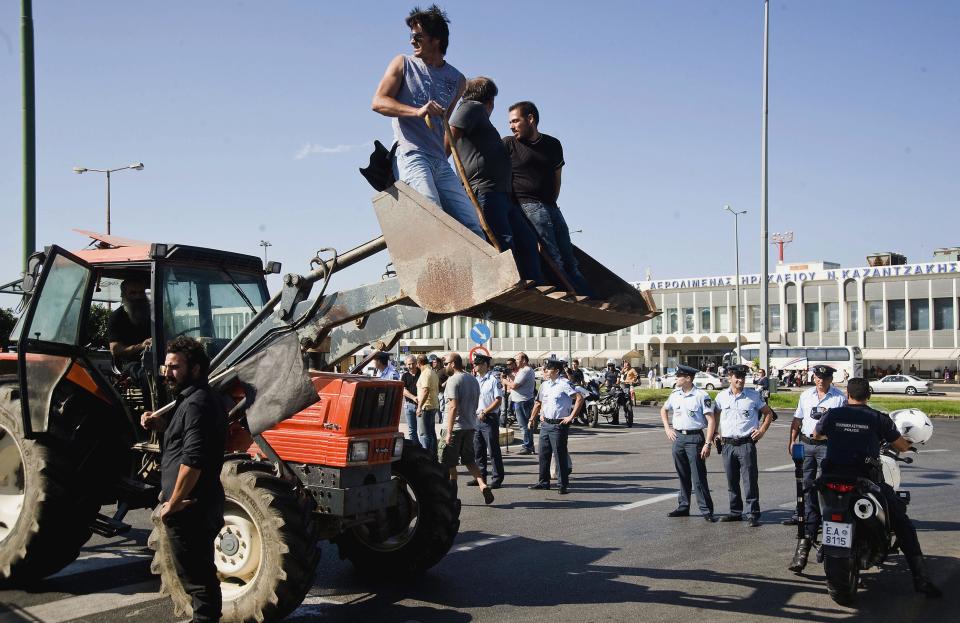 Protesting farmers use tractors to block the entrance of the Iraklio International Airport, Crete, Greece on Thursday, Oct. 4, 2012. The Cretan farmers, protesting pension cuts expected under new Greek austerity measures, attempted to block access to the airport, using tractors and other farm vehicles. Police used tear gas against the protesters who had gathered from across the island. (AP Photo/Bastian Parschau)