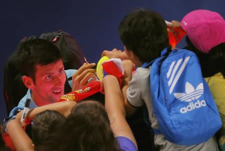 Tennis - Australian Open - Melbourne Park, Melbourne, Australia - 17/1/17 Serbia's Novak Djokovic signs autographs after winning his Men's singles first round match against Spain's Fernando Verdasco. REUTERS/Jason Reed