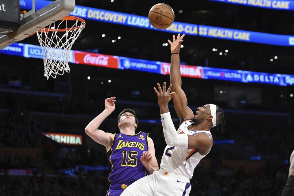 Phoenix Suns forward Josh Okogie, right, shoots as Los Angeles Lakers guard Austin Reaves defends during the first half of an NBA basketball game Friday, April 7, 2023, in Los Angeles. (AP Photo/Mark J. Terrill)