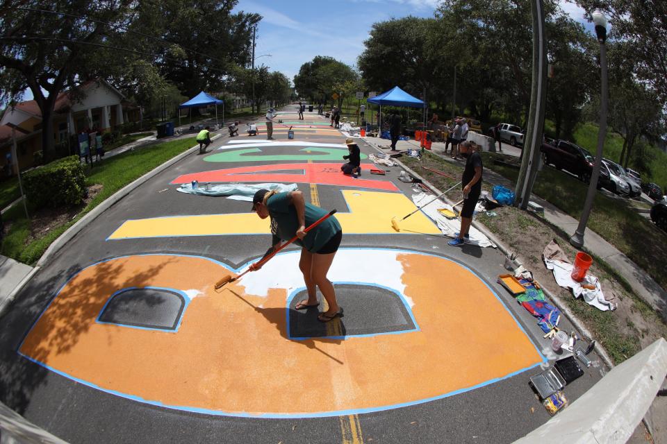 An artist painting part of the new Black Lives Matter street mural in front of the Dr. Carter G. Woodson African American Museum in St. Petersburg, Florida, this week. The project was meant to be completed before the city's Juneteenth celebrations on Friday. (Photo: Boyzell Hosey/Tampa Bay Times via AP)